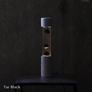点灯すると呼吸をするように流動的に形を変えながらコンクリートの筒を行き来する Dripping Lamp（ドリッピングランプ）